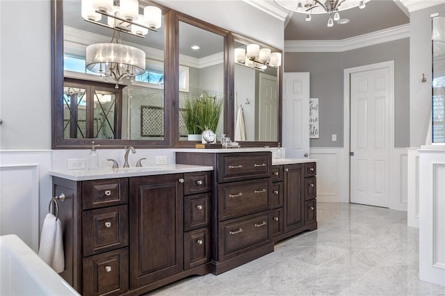 full bath with a notable chandelier, crown molding, a decorative wall, and a sink