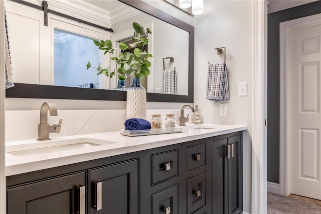 bathroom featuring crown molding, double vanity, and a sink