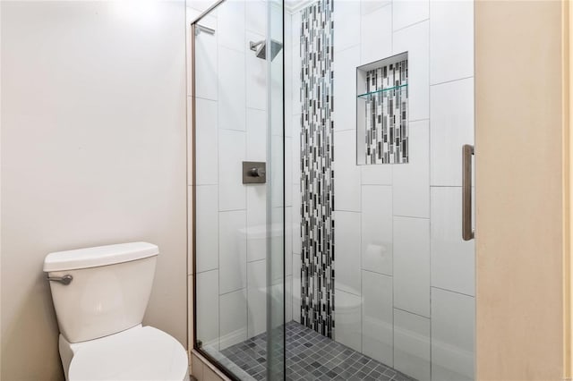 bathroom with a shower stall and toilet