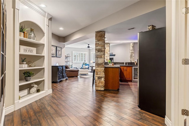 interior space featuring dark wood-type flooring, beverage cooler, visible vents, and ornate columns