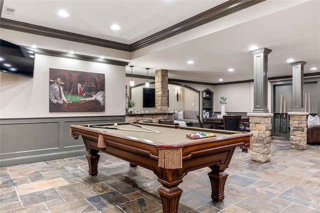 rec room with a wainscoted wall, ornamental molding, billiards, stone tile flooring, and decorative columns