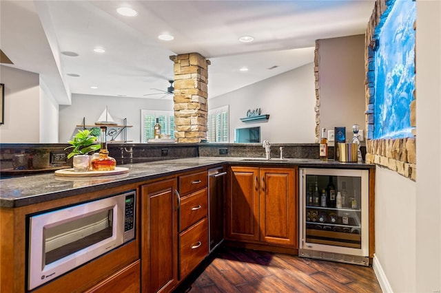 bar featuring stainless steel microwave, wine cooler, dark wood-style floors, a ceiling fan, and a sink