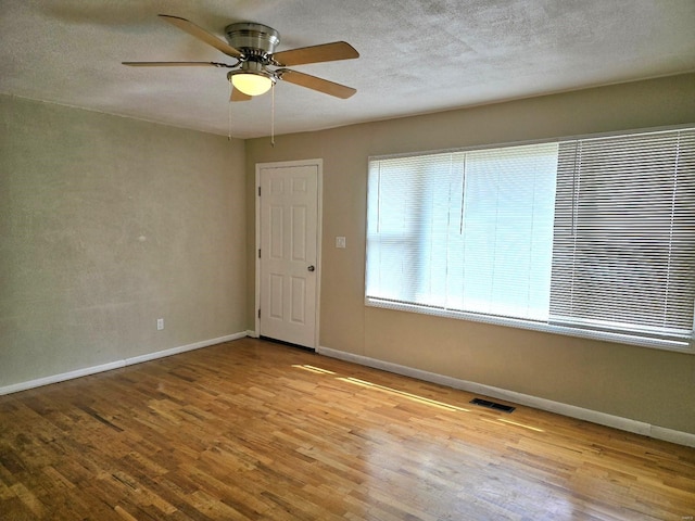 empty room featuring light hardwood / wood-style flooring, a textured ceiling, and ceiling fan