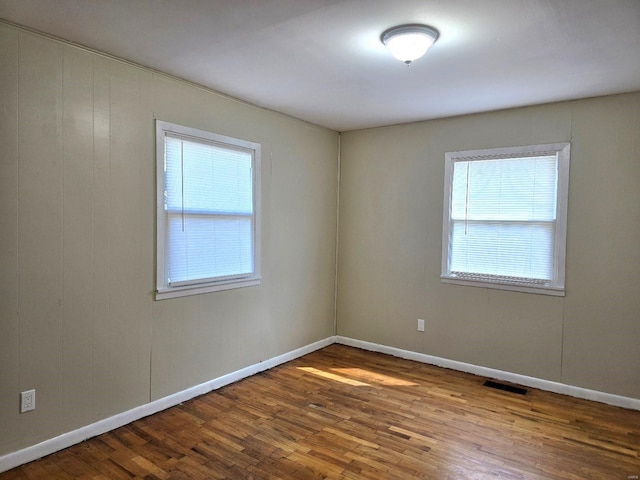 empty room featuring plenty of natural light and hardwood / wood-style floors