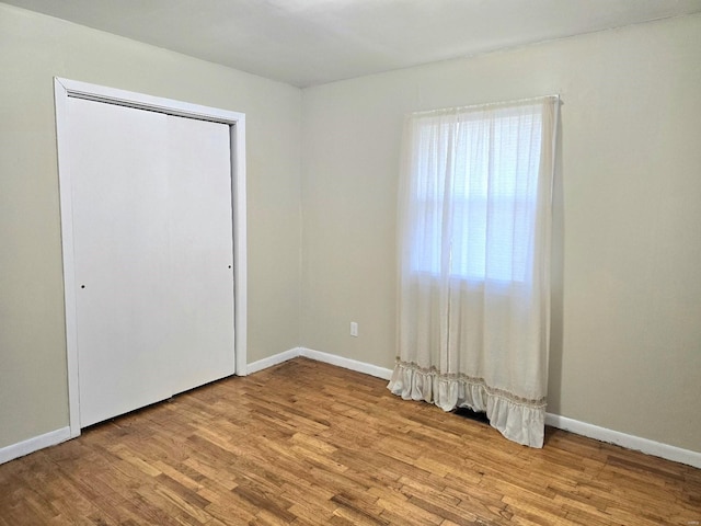 unfurnished bedroom with light hardwood / wood-style flooring and a closet