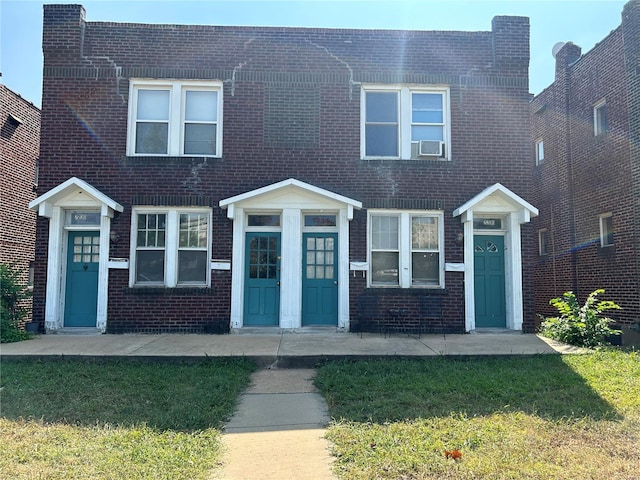 view of front of house featuring cooling unit and a front lawn