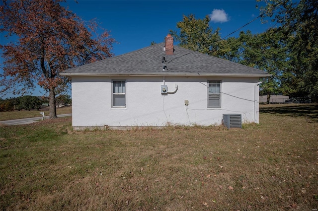 view of property exterior with central air condition unit and a lawn