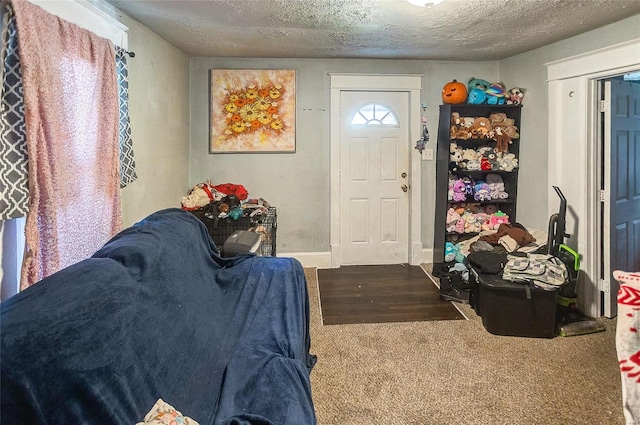 carpeted foyer entrance featuring a textured ceiling