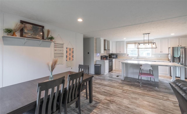 dining area featuring light hardwood / wood-style floors and a textured ceiling