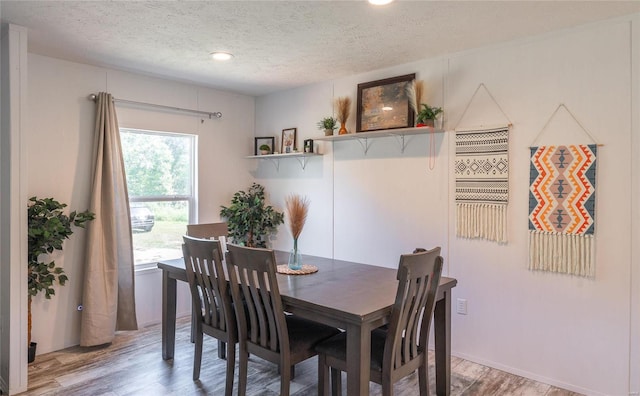 dining space featuring a textured ceiling and hardwood / wood-style flooring