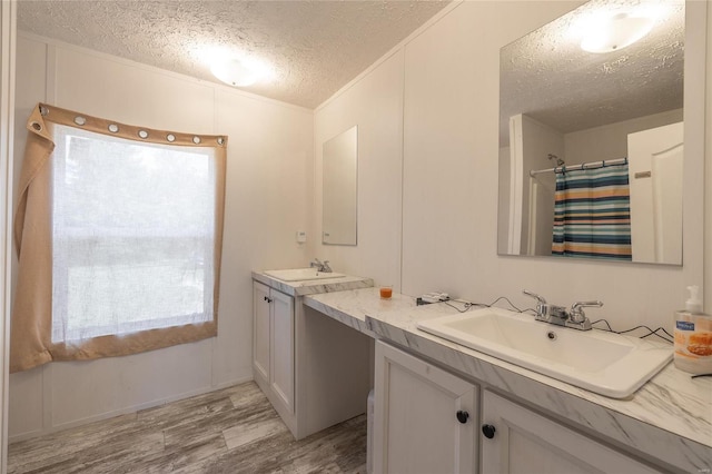 bathroom featuring vanity, a textured ceiling, wood-type flooring, and plenty of natural light