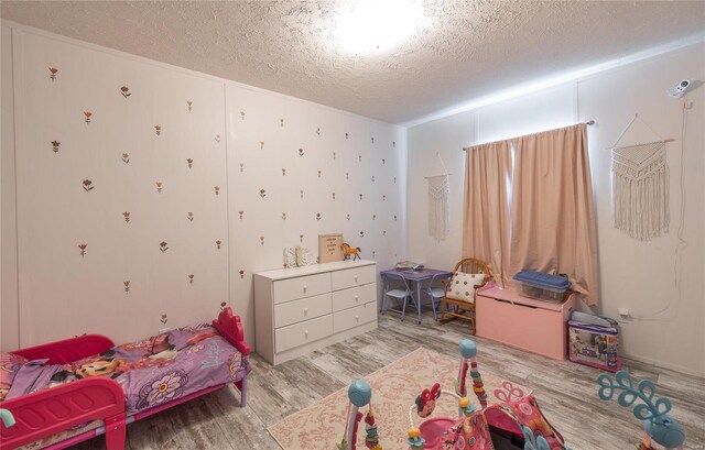 bedroom featuring light hardwood / wood-style flooring and a textured ceiling