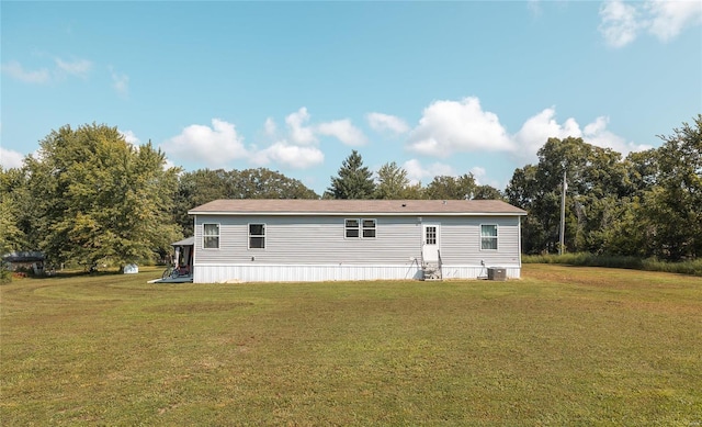 rear view of property with a lawn and central AC unit