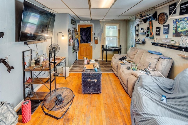 living room featuring a drop ceiling and light hardwood / wood-style flooring