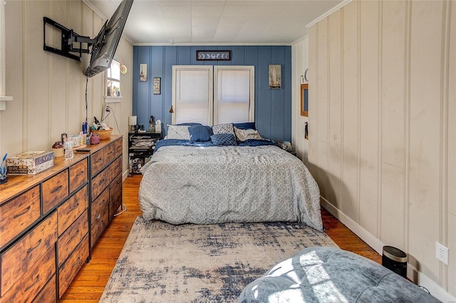 bedroom featuring wood-type flooring and ornamental molding