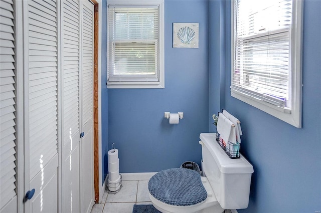 bathroom featuring a wealth of natural light, toilet, and tile patterned flooring