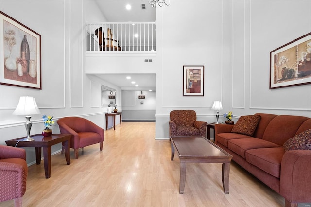 living room featuring a towering ceiling and light wood-type flooring