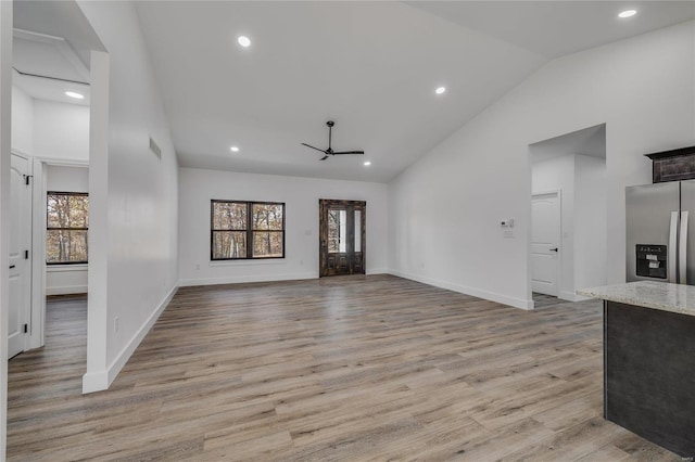 unfurnished living room featuring ceiling fan, high vaulted ceiling, and light wood-type flooring