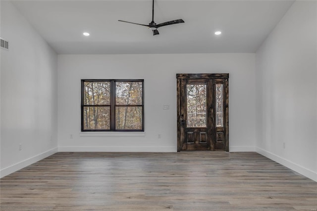 empty room featuring ceiling fan, plenty of natural light, and light hardwood / wood-style flooring