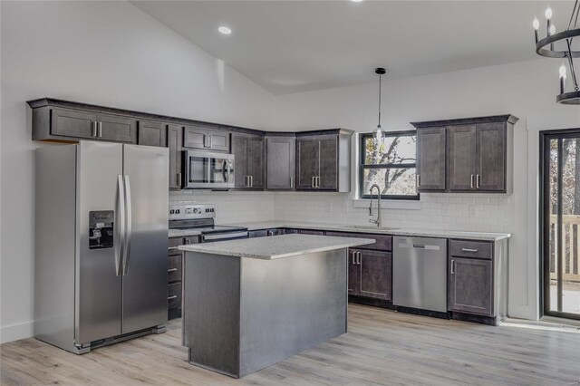 kitchen with sink, hanging light fixtures, dark brown cabinetry, and stainless steel appliances