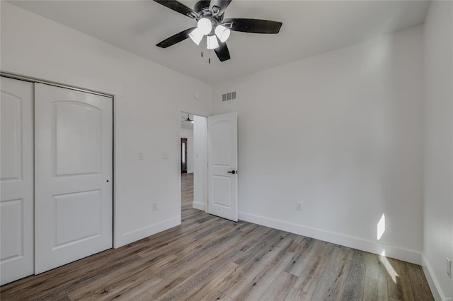 unfurnished bedroom with ceiling fan, a closet, and light hardwood / wood-style flooring