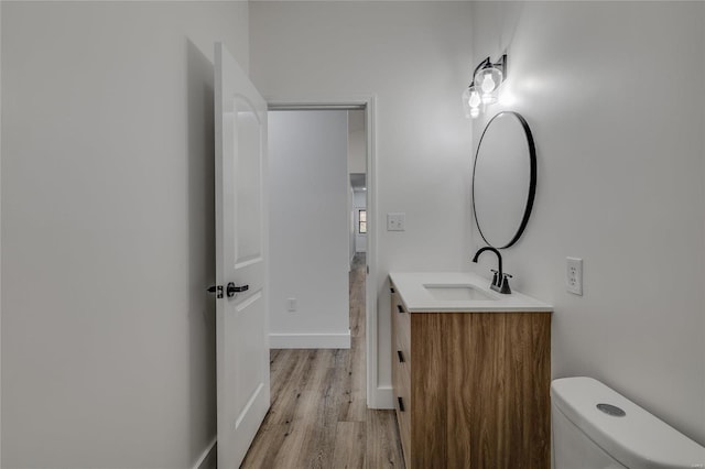 bathroom featuring toilet, wood-type flooring, and vanity