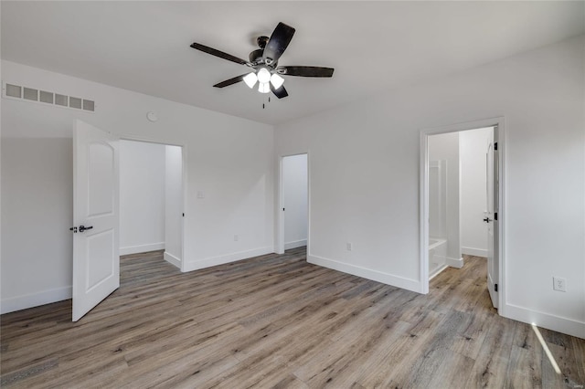 unfurnished bedroom featuring ceiling fan, connected bathroom, and light hardwood / wood-style flooring