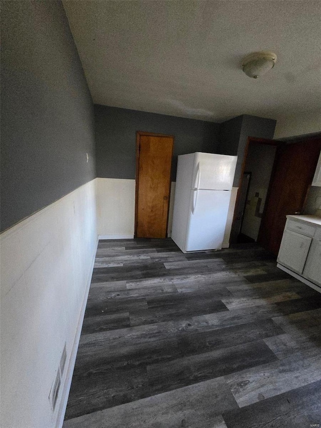 kitchen with dark hardwood / wood-style flooring, white fridge, and a textured ceiling