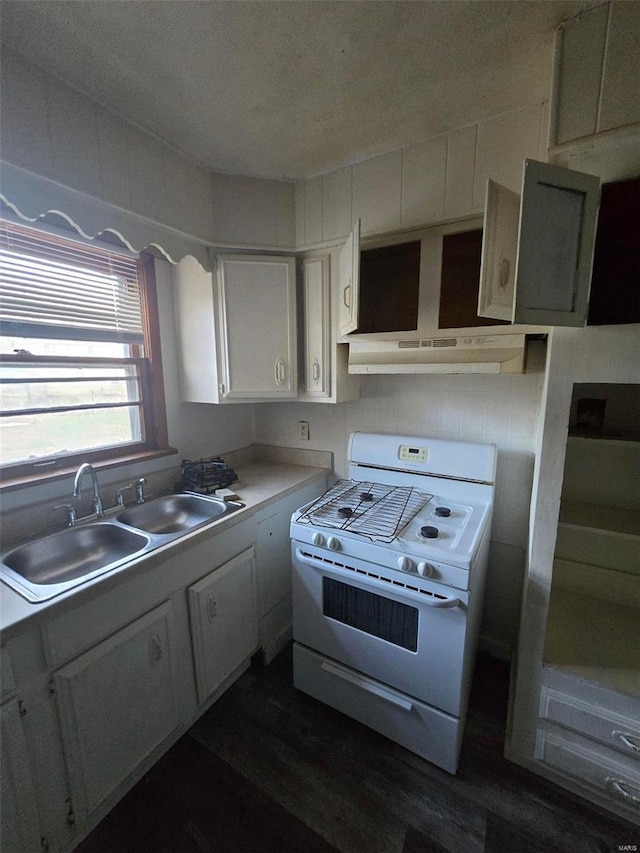 kitchen featuring dark hardwood / wood-style flooring, sink, white gas range oven, and white cabinets