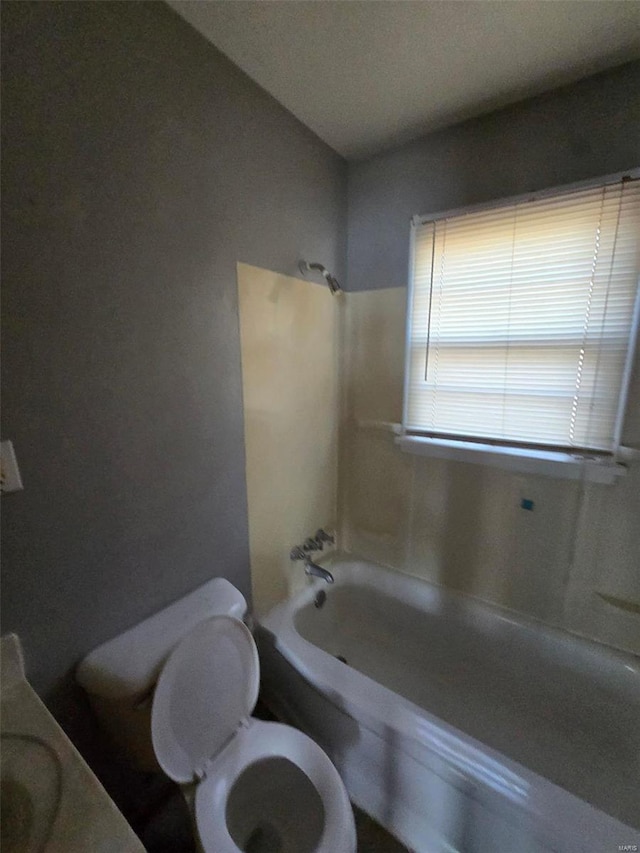 bathroom with toilet and bathing tub / shower combination