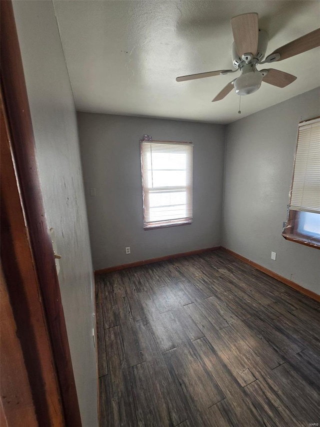 empty room with dark hardwood / wood-style flooring and ceiling fan