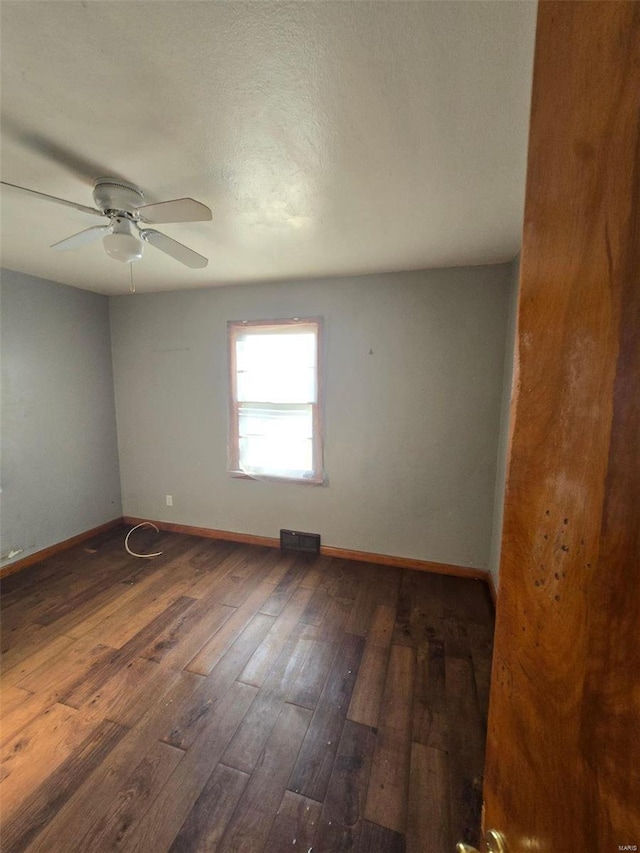 unfurnished room featuring dark wood-type flooring and ceiling fan