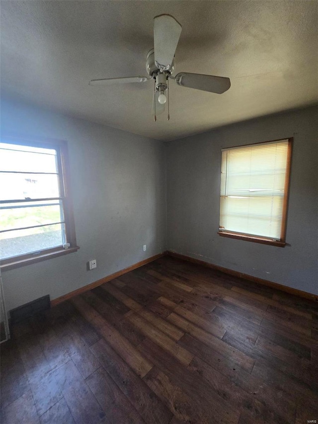 spare room featuring dark wood-type flooring and ceiling fan