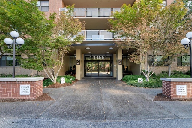 entrance to property with stucco siding and a balcony