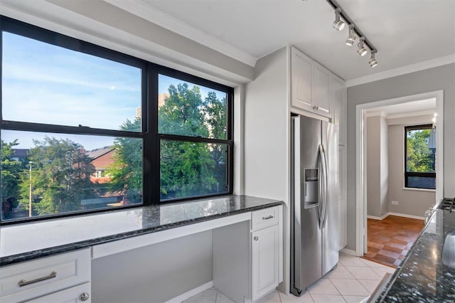 kitchen featuring built in study area, stainless steel fridge with ice dispenser, white cabinetry, and dark stone countertops