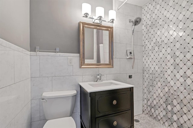 bathroom featuring tile walls, vanity, toilet, and tiled shower