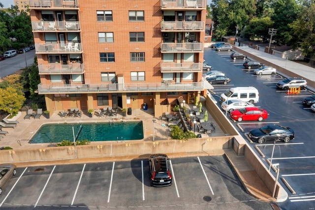 view of property featuring uncovered parking and a community pool