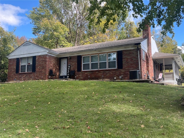 view of front of house with cooling unit and a front lawn