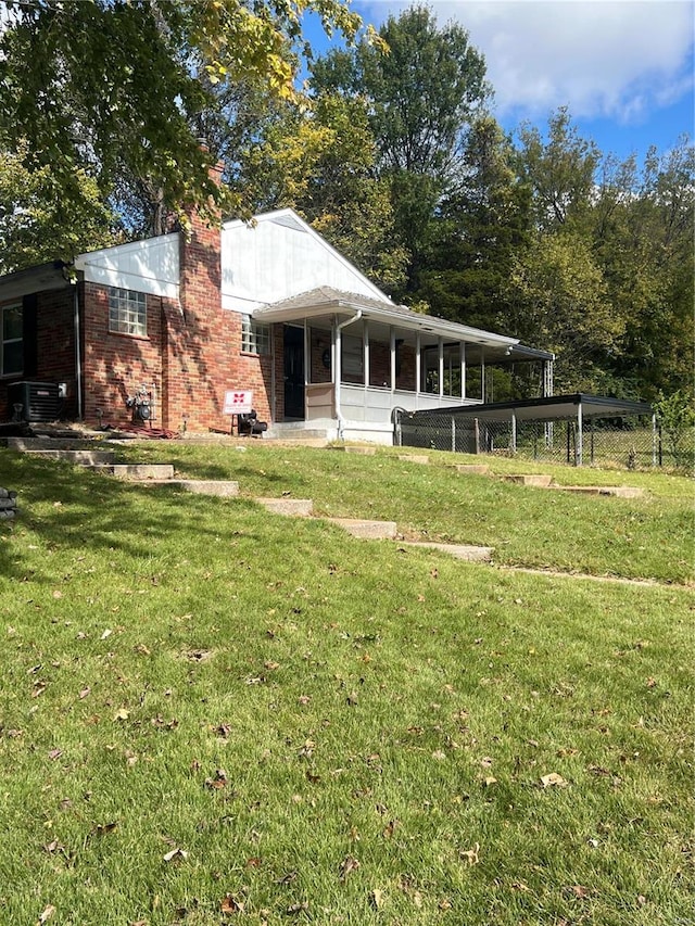 view of front of property with central air condition unit and a front lawn