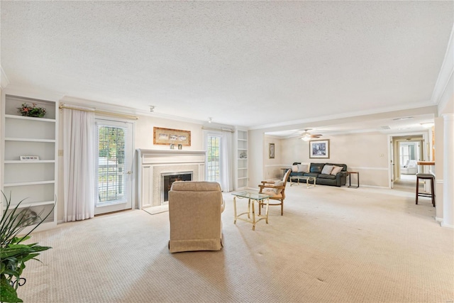 living room featuring a textured ceiling, ceiling fan, crown molding, light colored carpet, and built in shelves