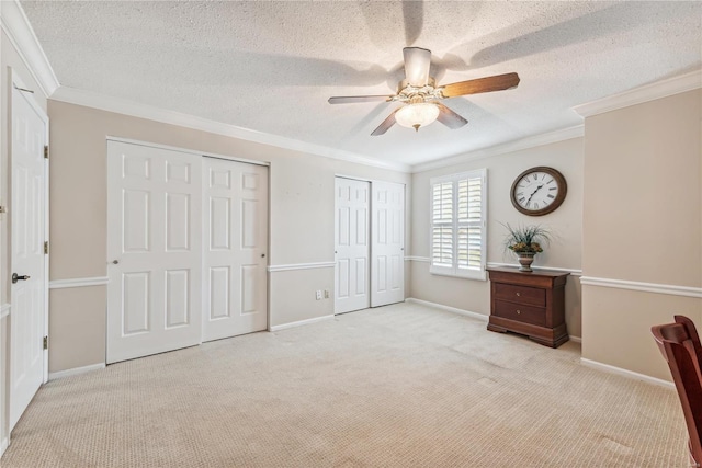 unfurnished bedroom featuring a textured ceiling, light colored carpet, and ceiling fan