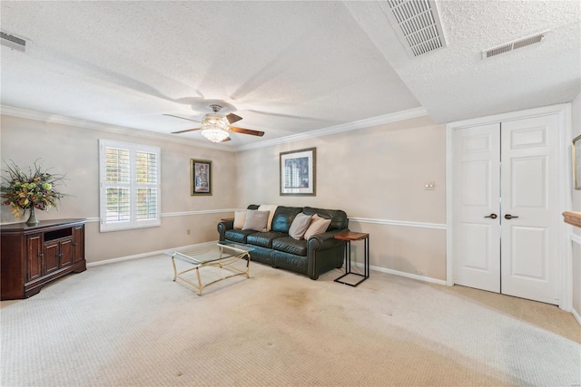 living room with ceiling fan, light carpet, a textured ceiling, and crown molding