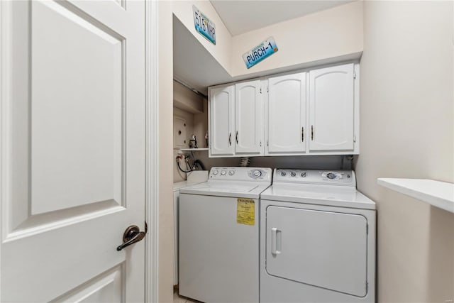 clothes washing area featuring washer and clothes dryer and cabinets