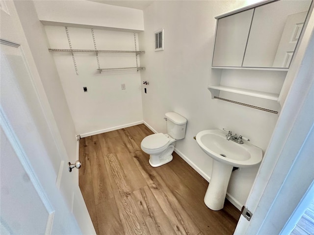 bathroom featuring hardwood / wood-style flooring and toilet