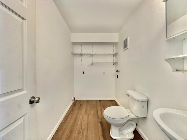 bathroom with toilet and hardwood / wood-style floors