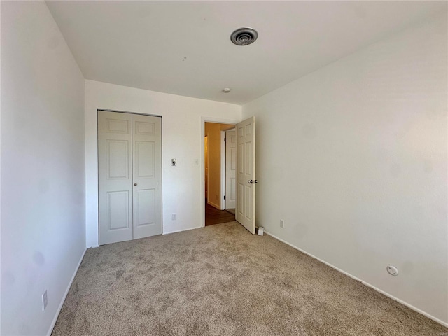 unfurnished bedroom featuring carpet flooring and a closet