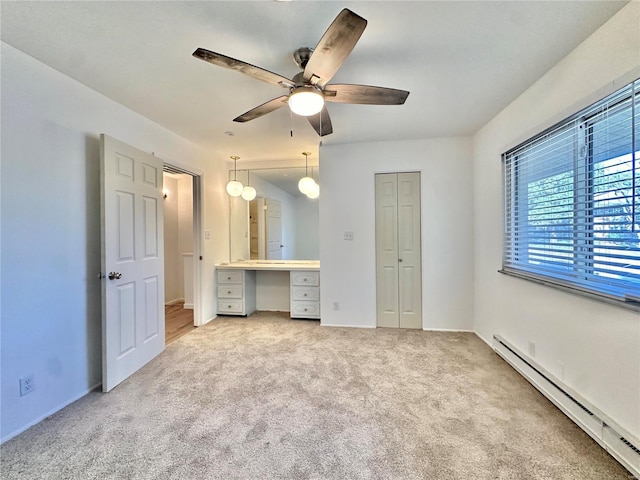 unfurnished bedroom featuring a baseboard heating unit, light carpet, and ceiling fan