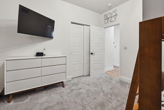 unfurnished bedroom with light colored carpet and a closet