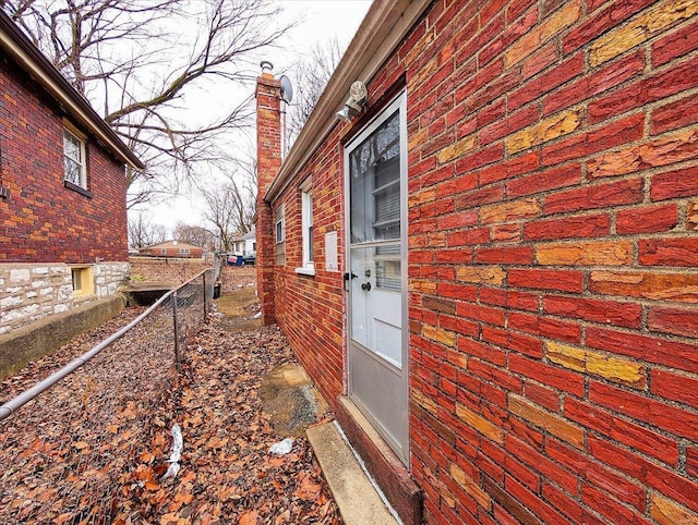 view of side of property featuring fence and a chimney