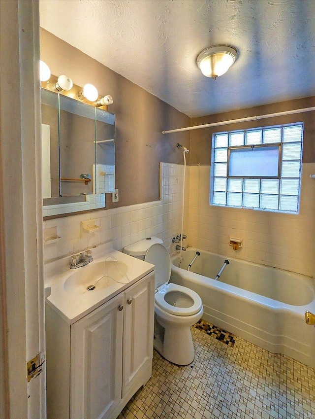 bathroom with tile walls, toilet, shower / bath combination, tile patterned floors, and a textured ceiling